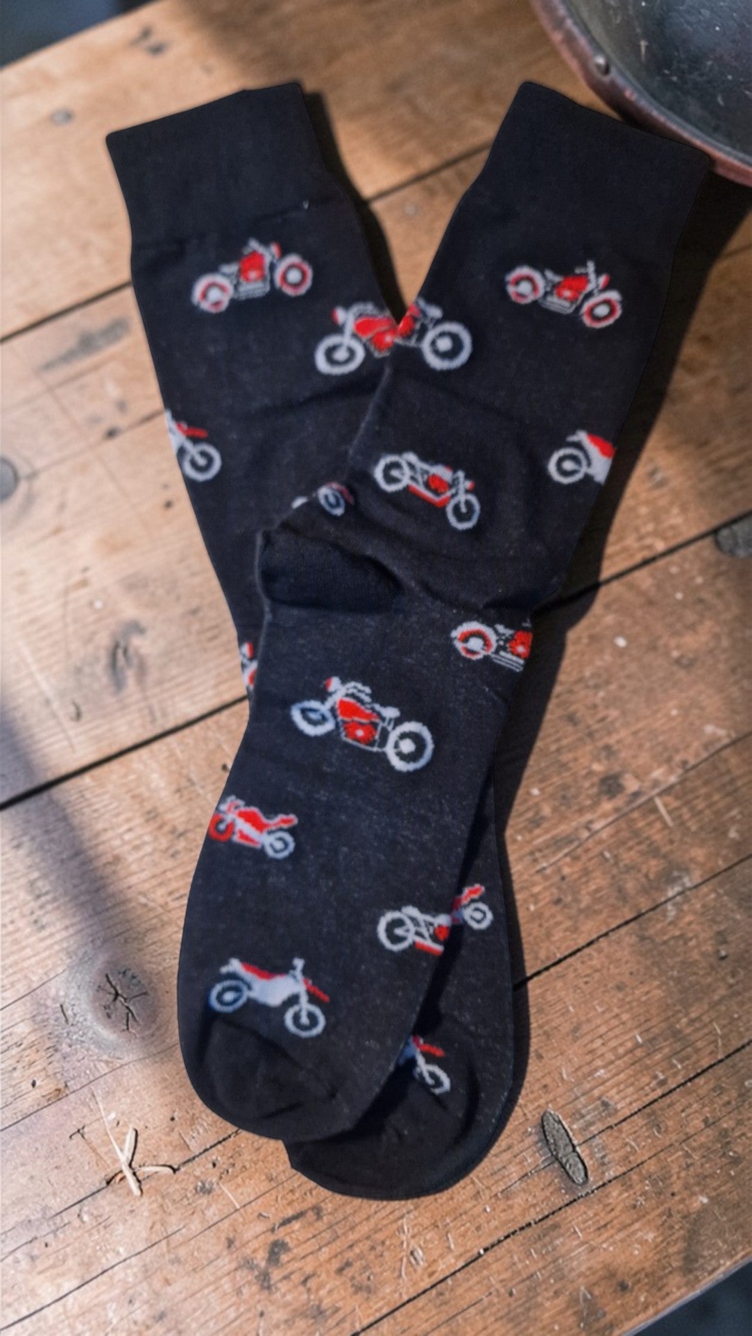 Black socks with motorcycle pattern on a wooden surface