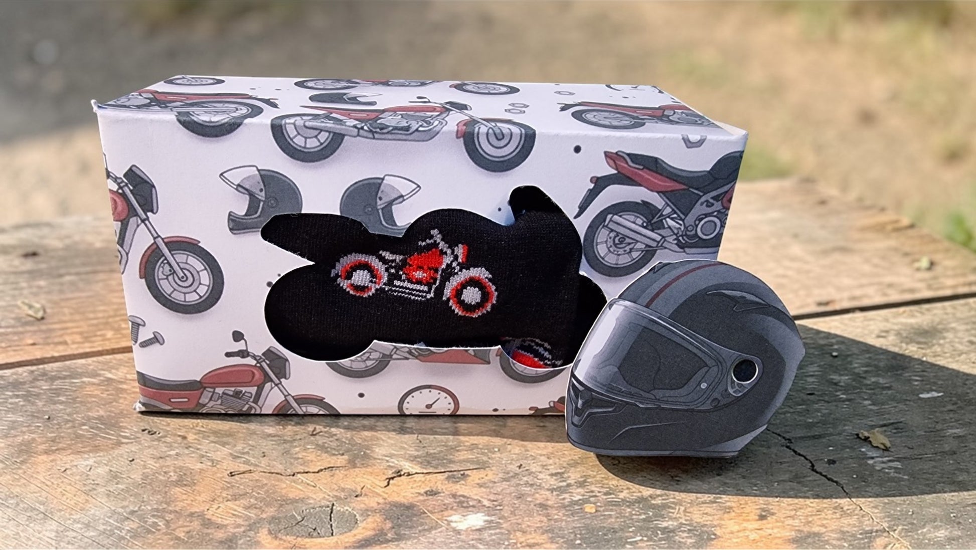 Black motorcycle helmet with a decorative design on a box featuring motorcycle illustrations.