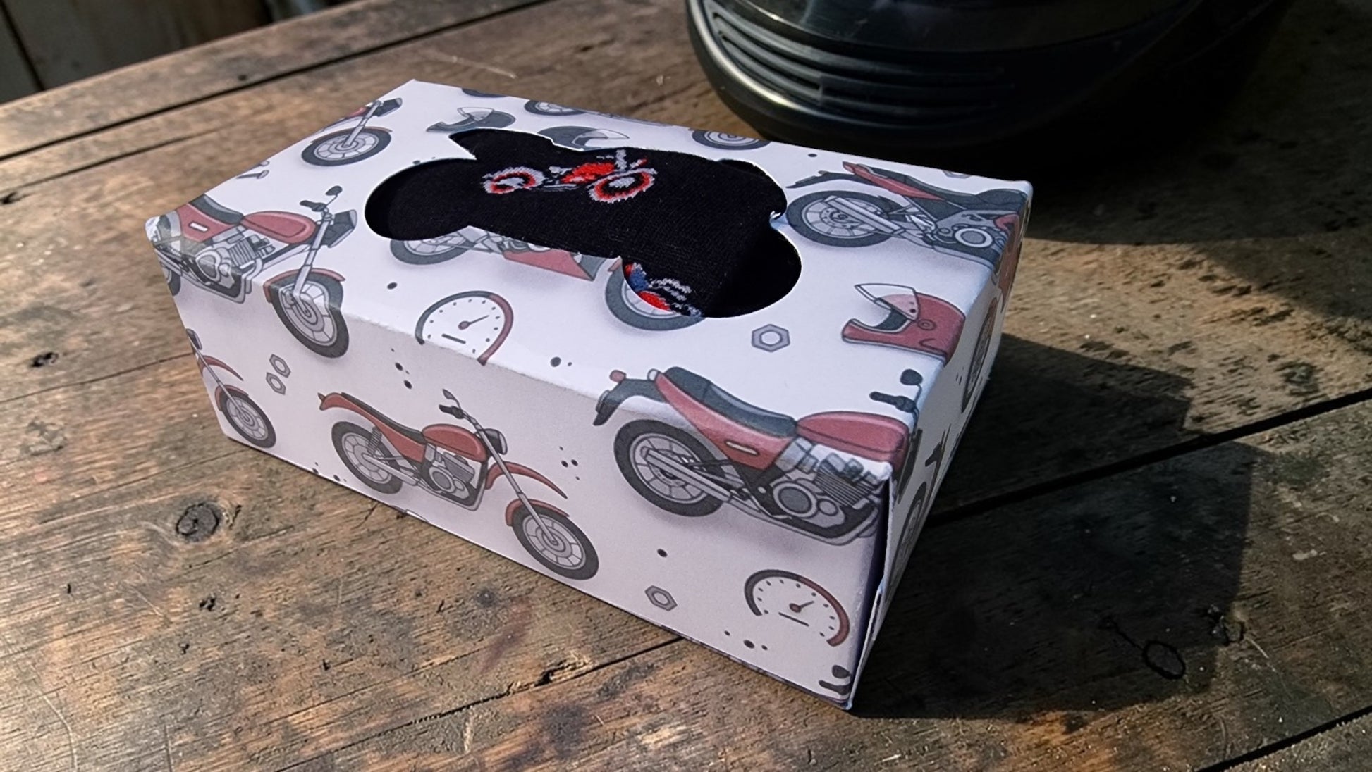 Tissue box cover with motorcycle design on a wooden surface
