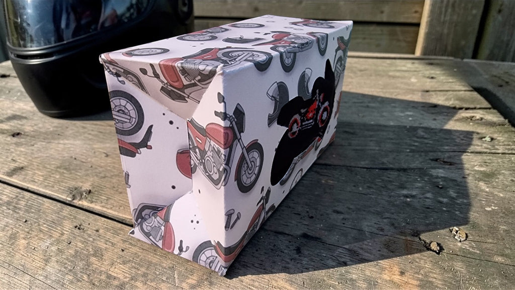 Rectangular box with motorcycle design on a wooden surface