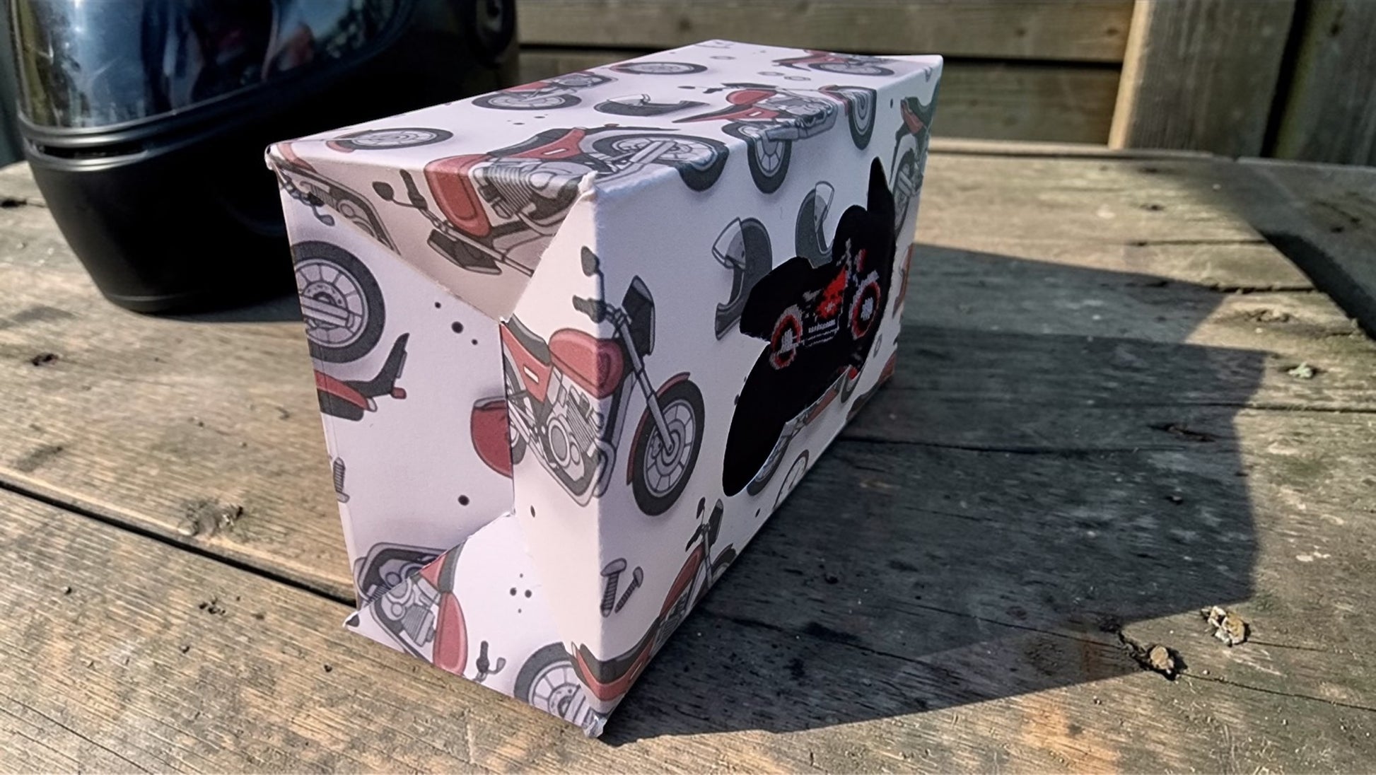 Rectangular box with motorcycle design on a wooden surface