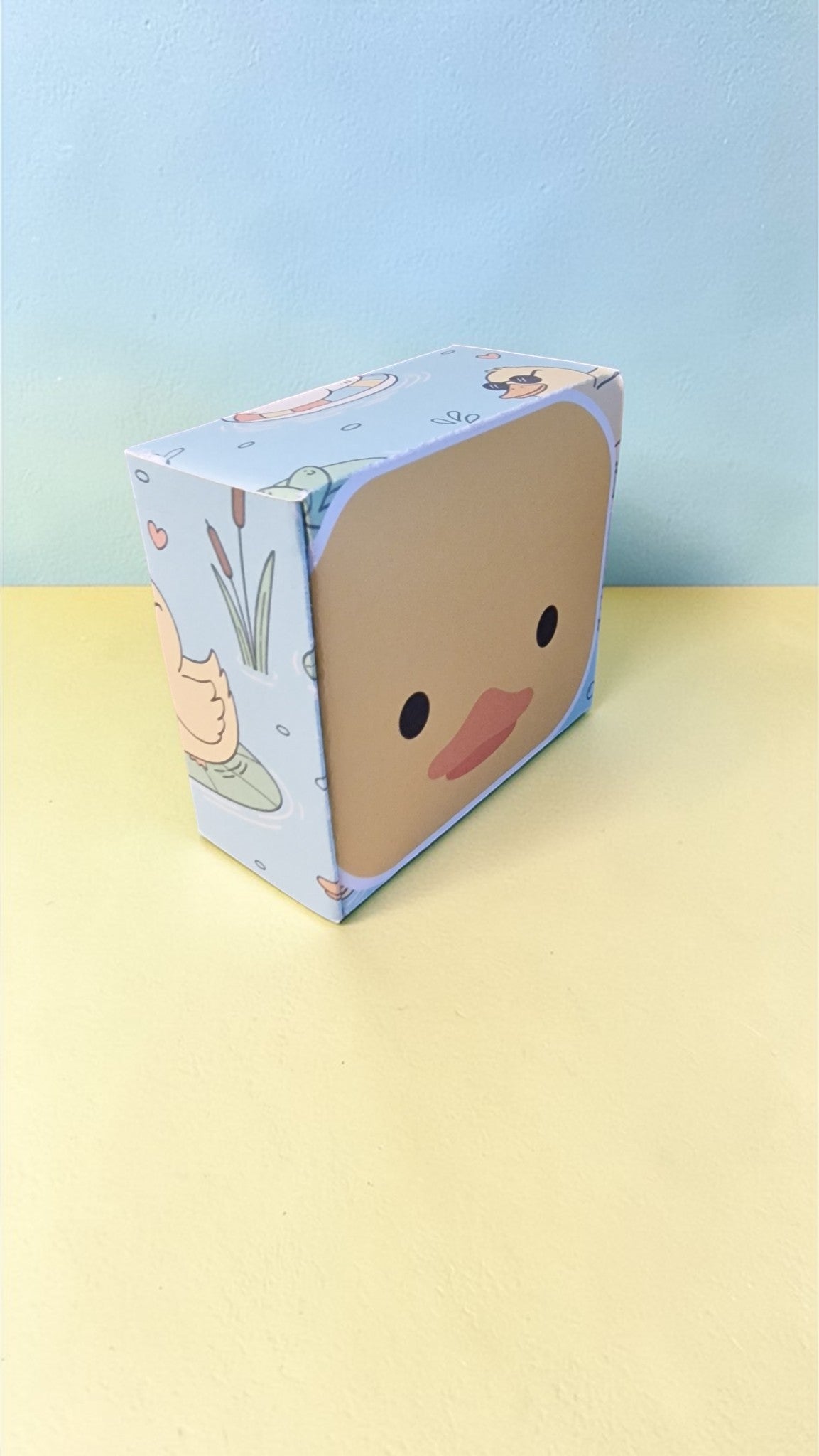 Cartoon character box on a yellow surface with a light blue background