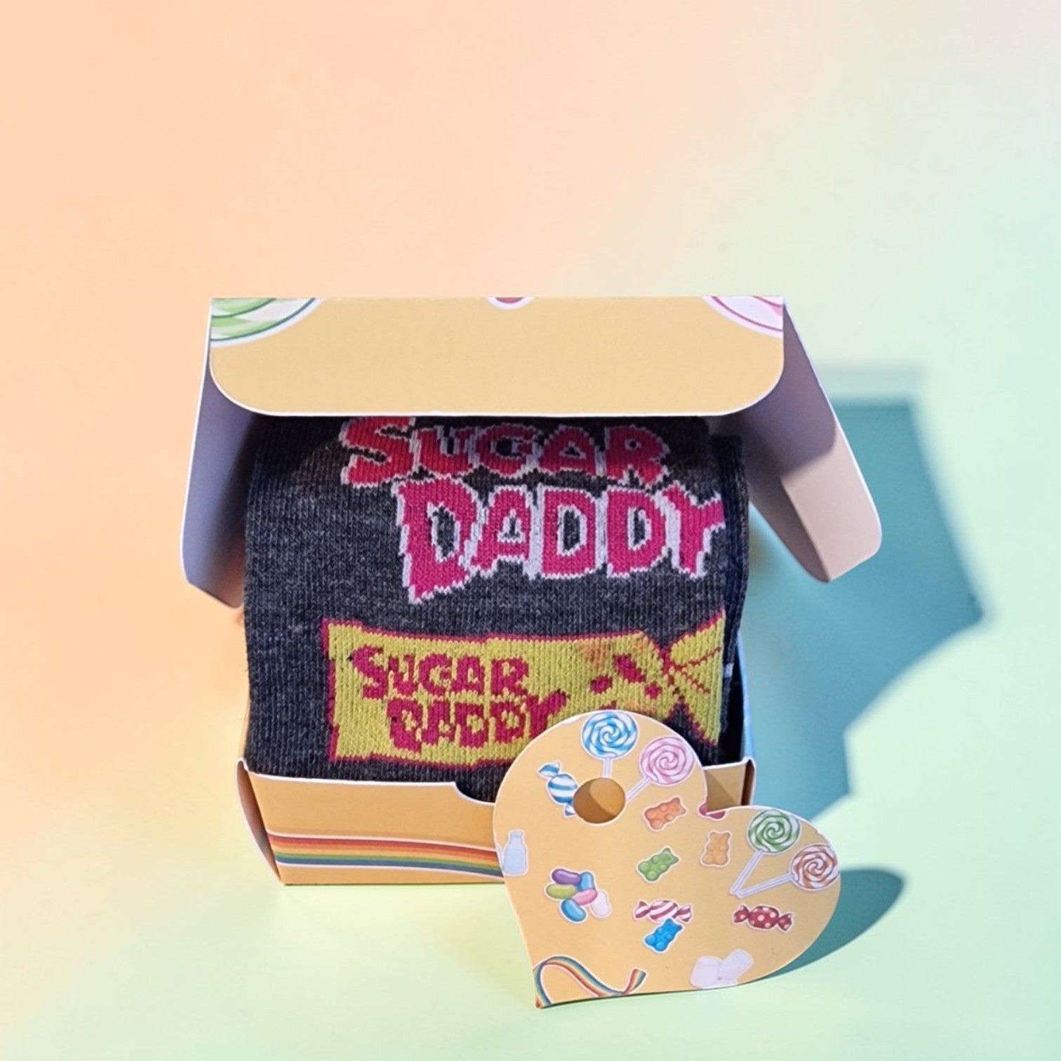 Socks with 'Sugar Daddy' text in a box on a gradient background