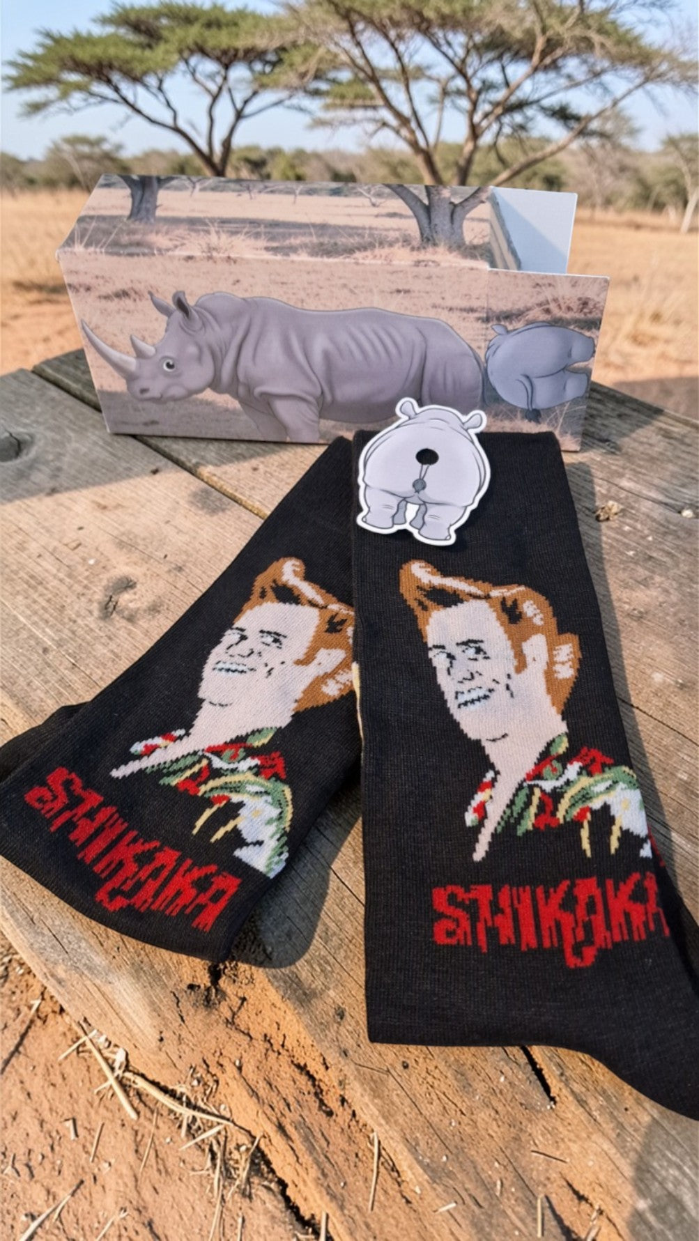 Black socks with artistic designs and 'Shikoka' branding on a wooden surface with a natural background.