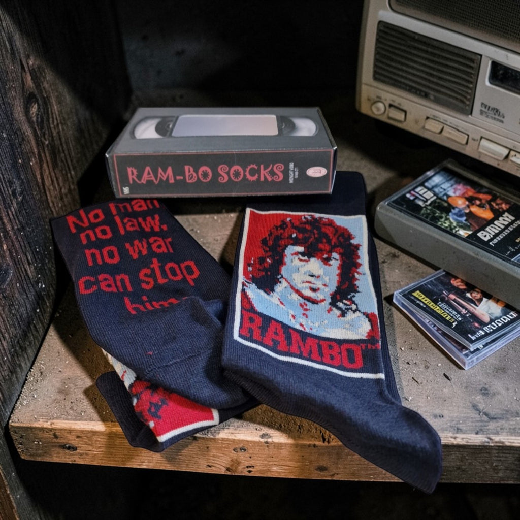 Rambo-themed socks with VHS tapes and a vintage radio in the background