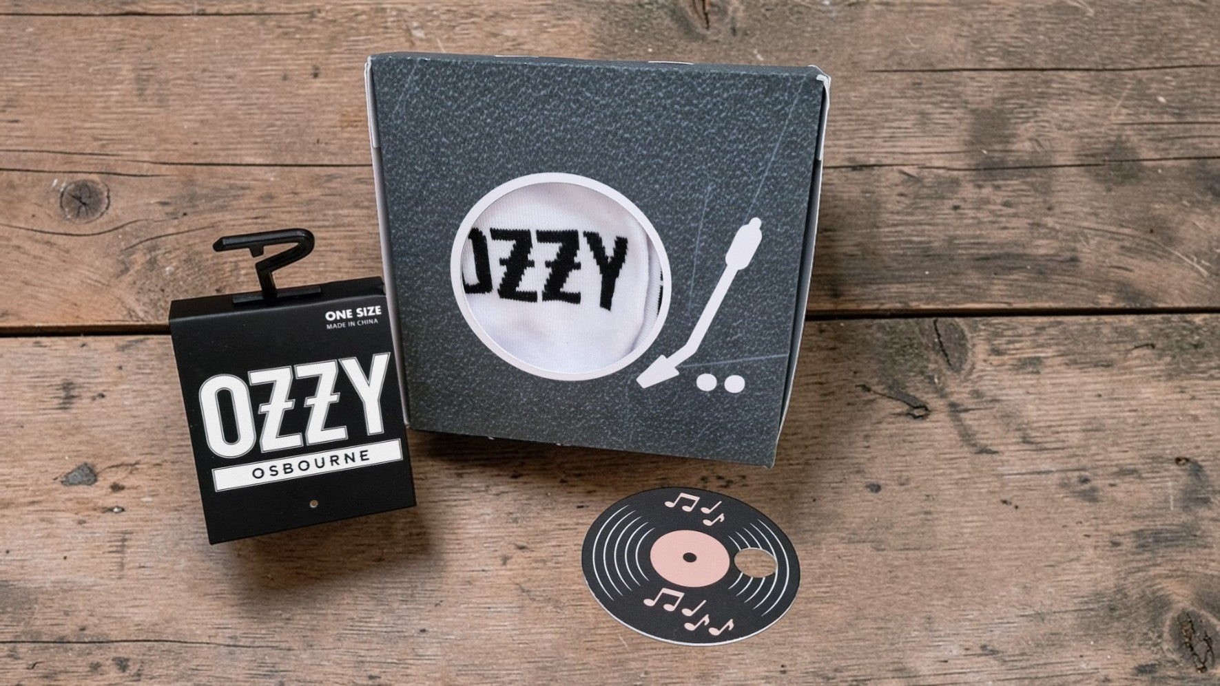 Ozzy Osbourne branded items including a record and a box on a wooden surface