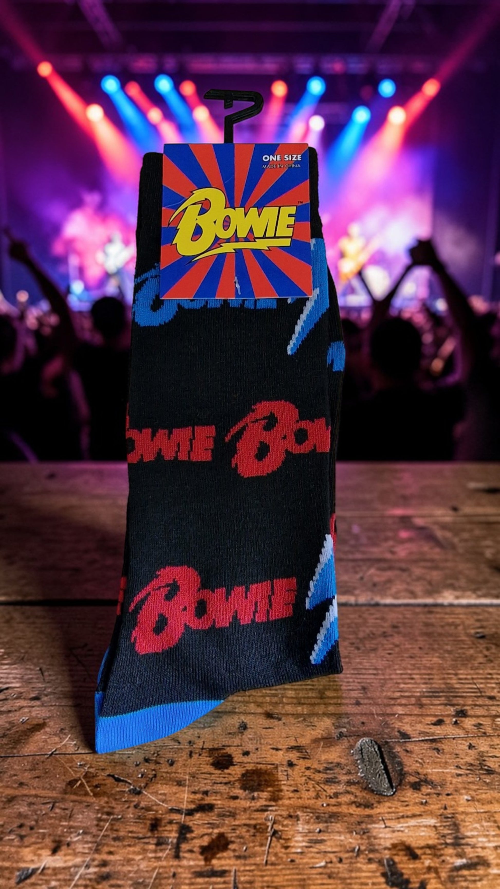 Sock with Bowie logo on a wooden surface with a concert background
