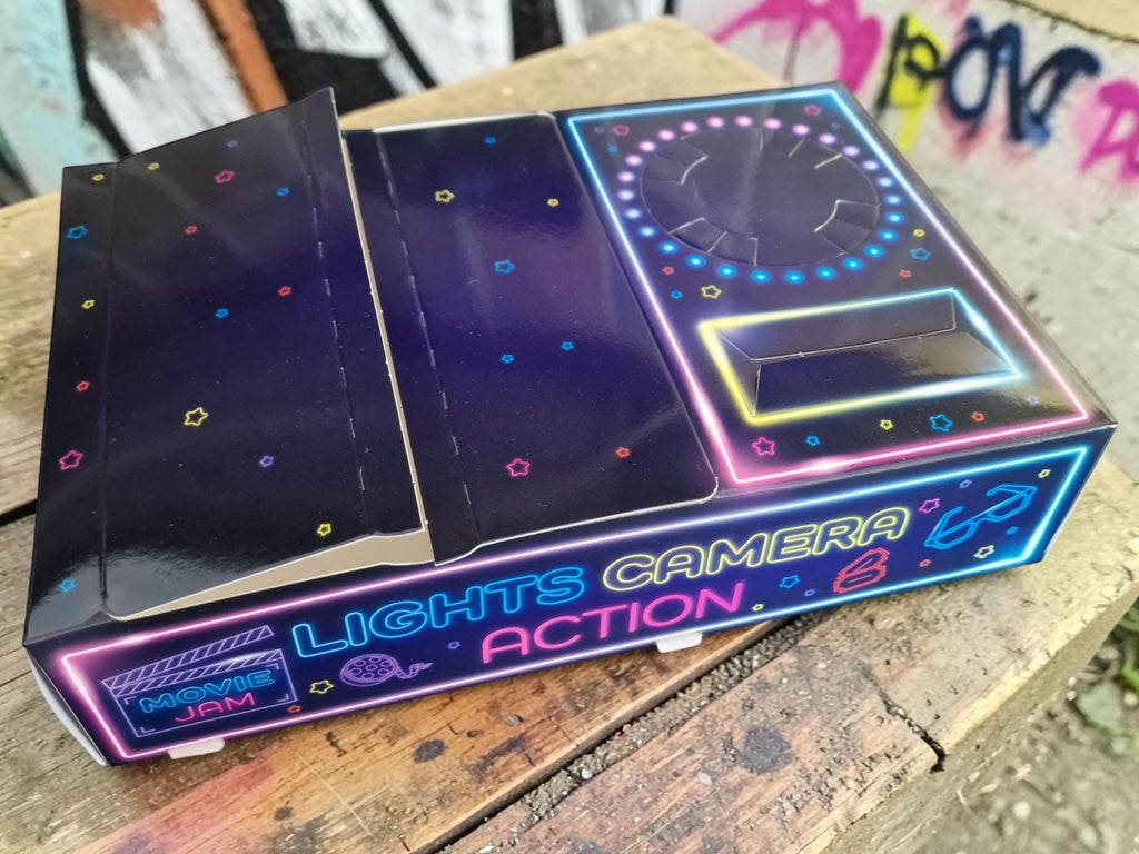 Neon sign with 'Lights Camera Action' text on a wooden surface
