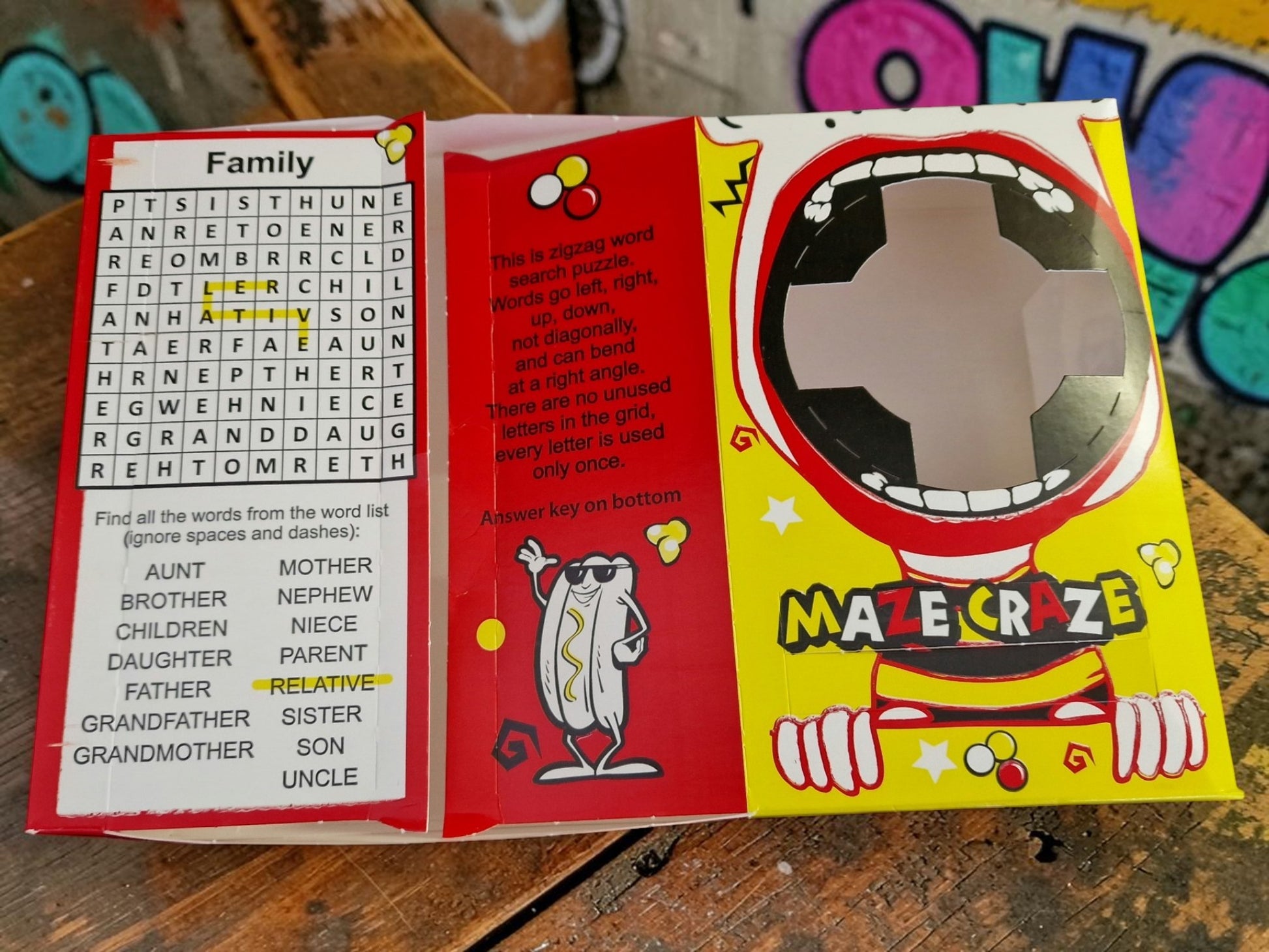 Maze Craze game book with word search and maze activities on a wooden surface.