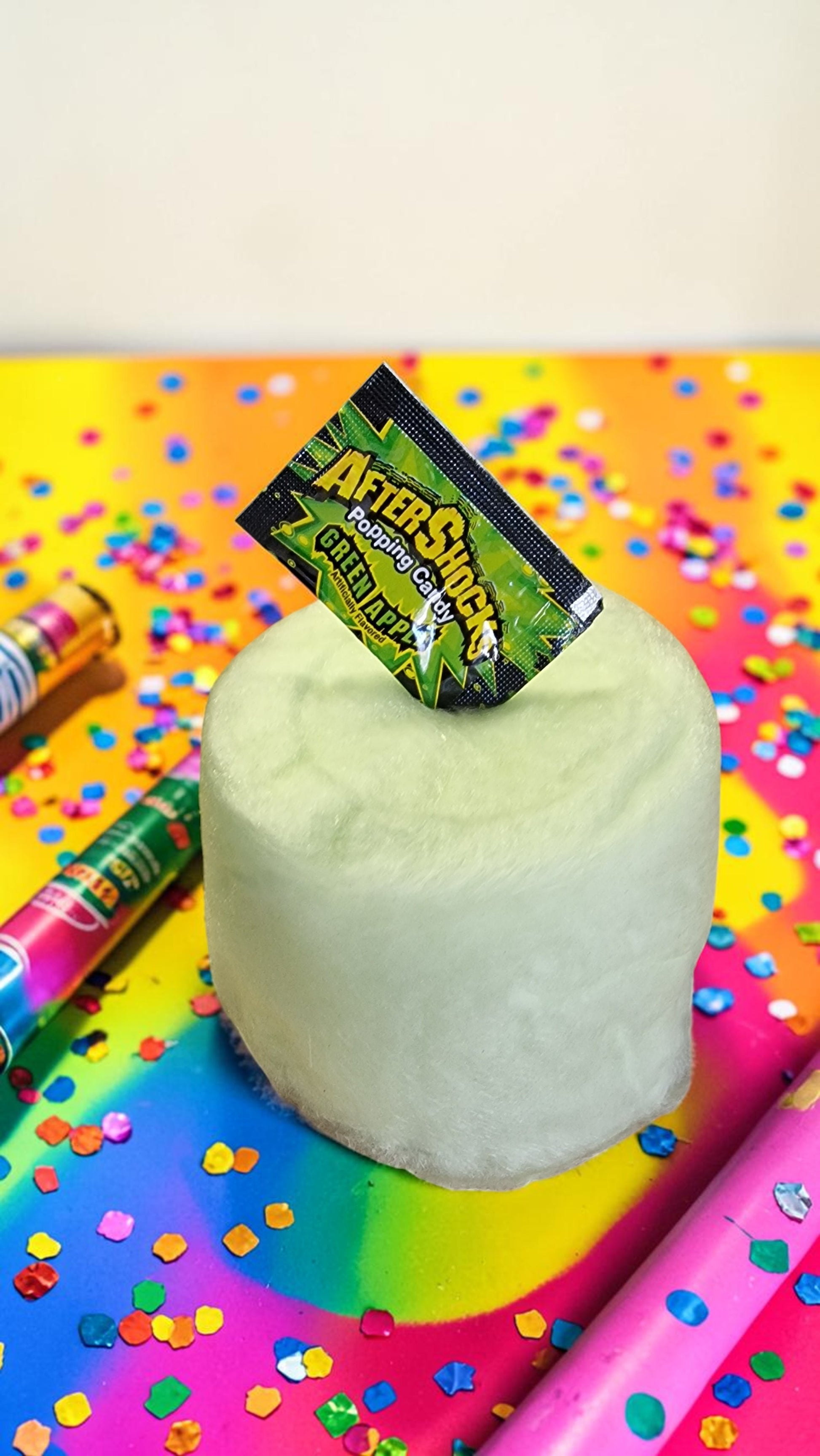 White cylindrical object with a colorful AfterShokz logo on a multicolored confetti background