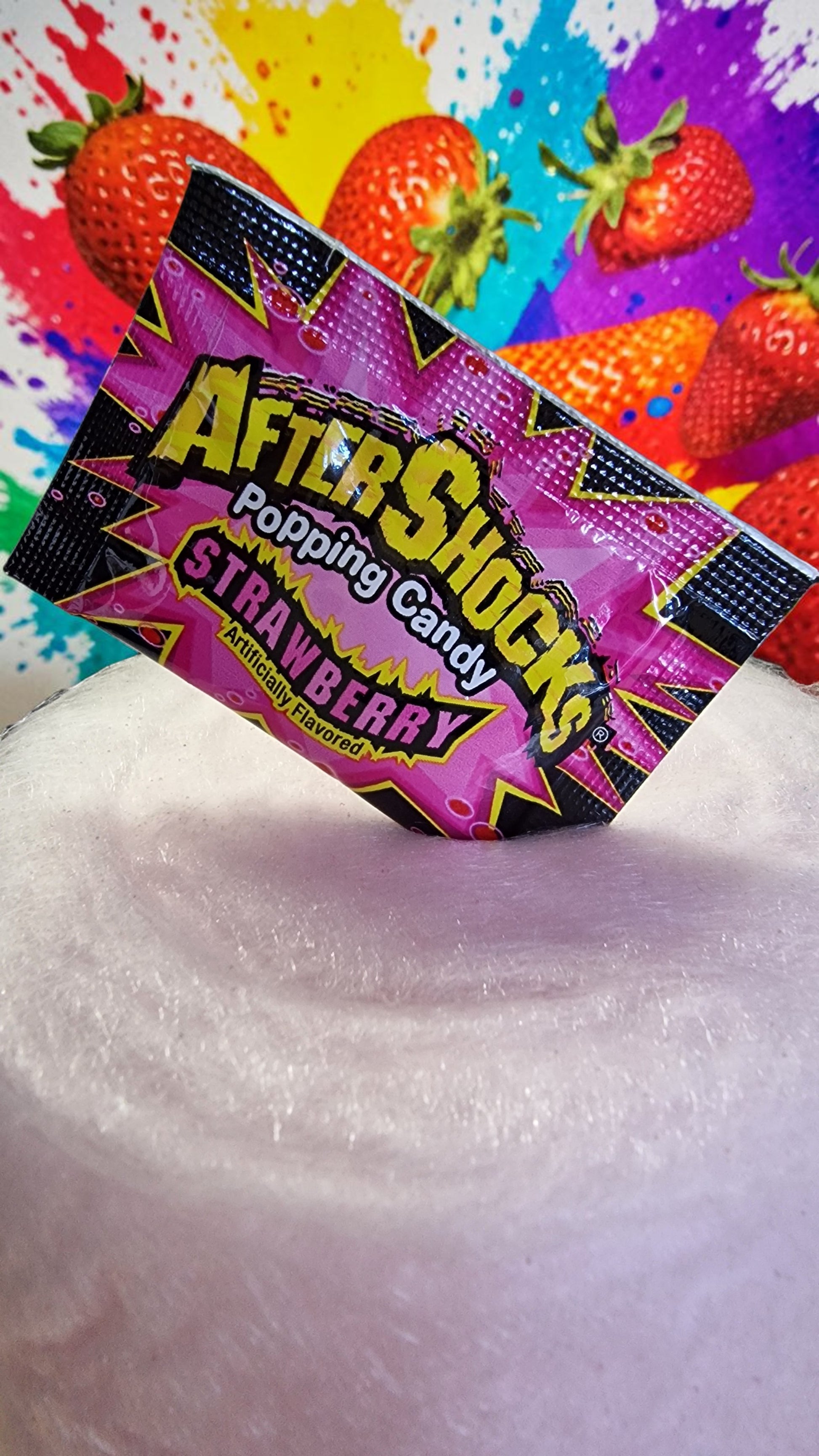 AfterShocks popping candy package with strawberries in the background
