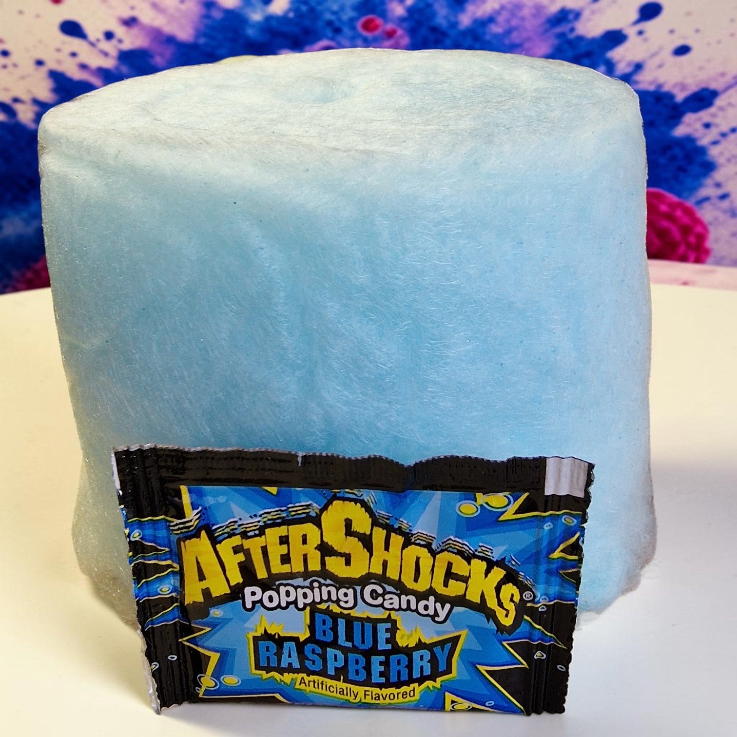 Blue raspberry candy pop with packaging on a white surface
