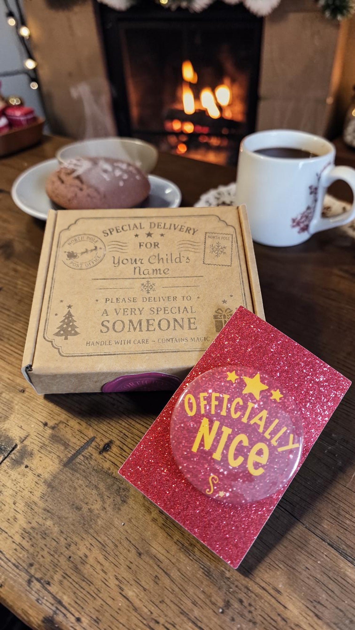 Box labeled 'Special Delivery for Your Child's Home' with a red card reading 'Officially Nice' on a wooden table with a fireplace in the background.