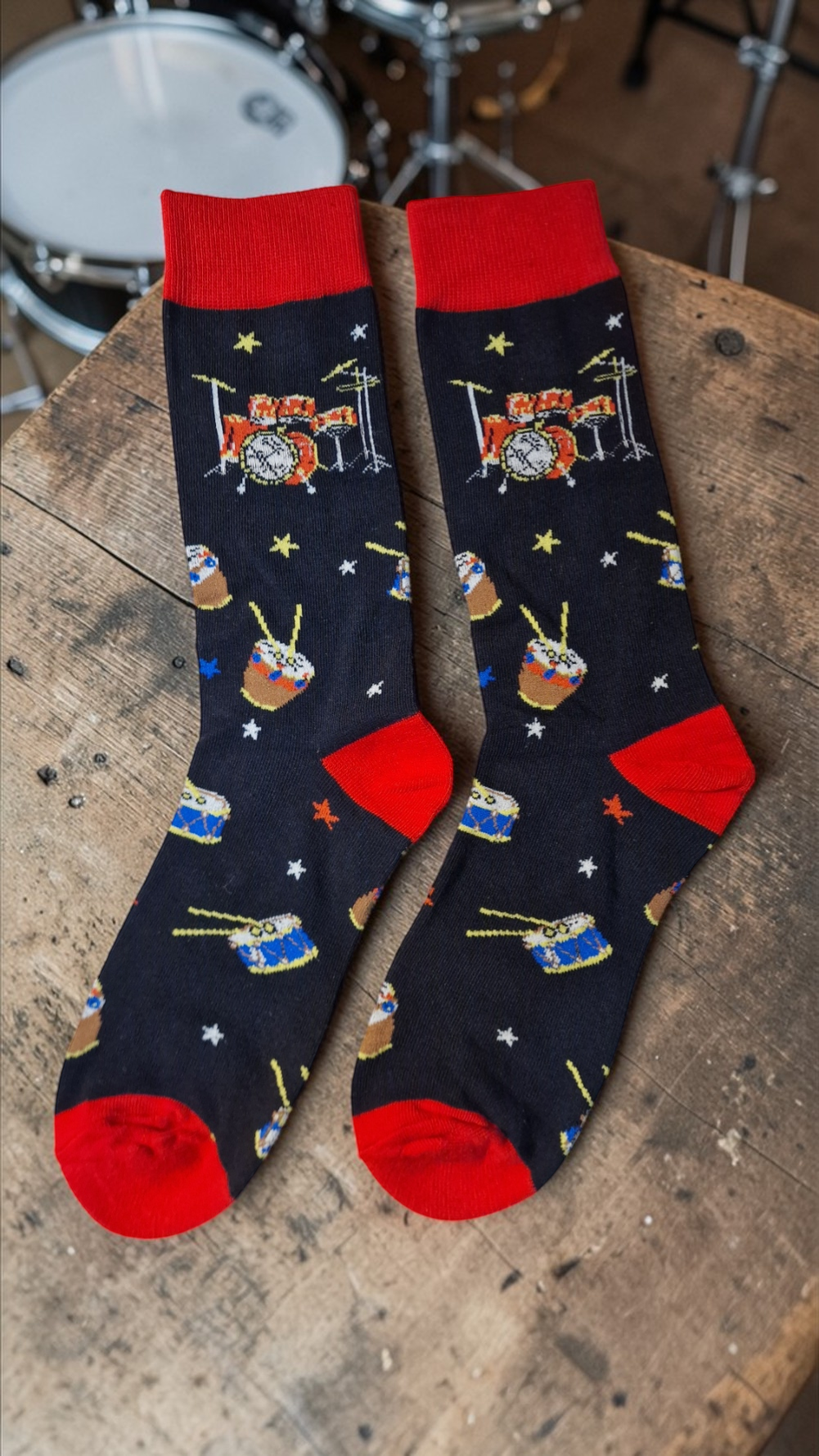 Pair of socks with drum design on a wooden surface