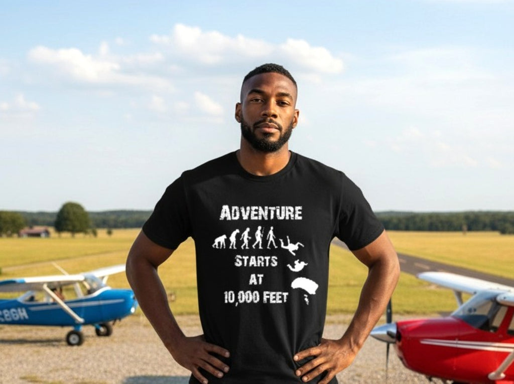 Man wearing a black t-shirt with 'Adventure Starts at 10,000 Feet' text and airplane graphics on an airfield background.