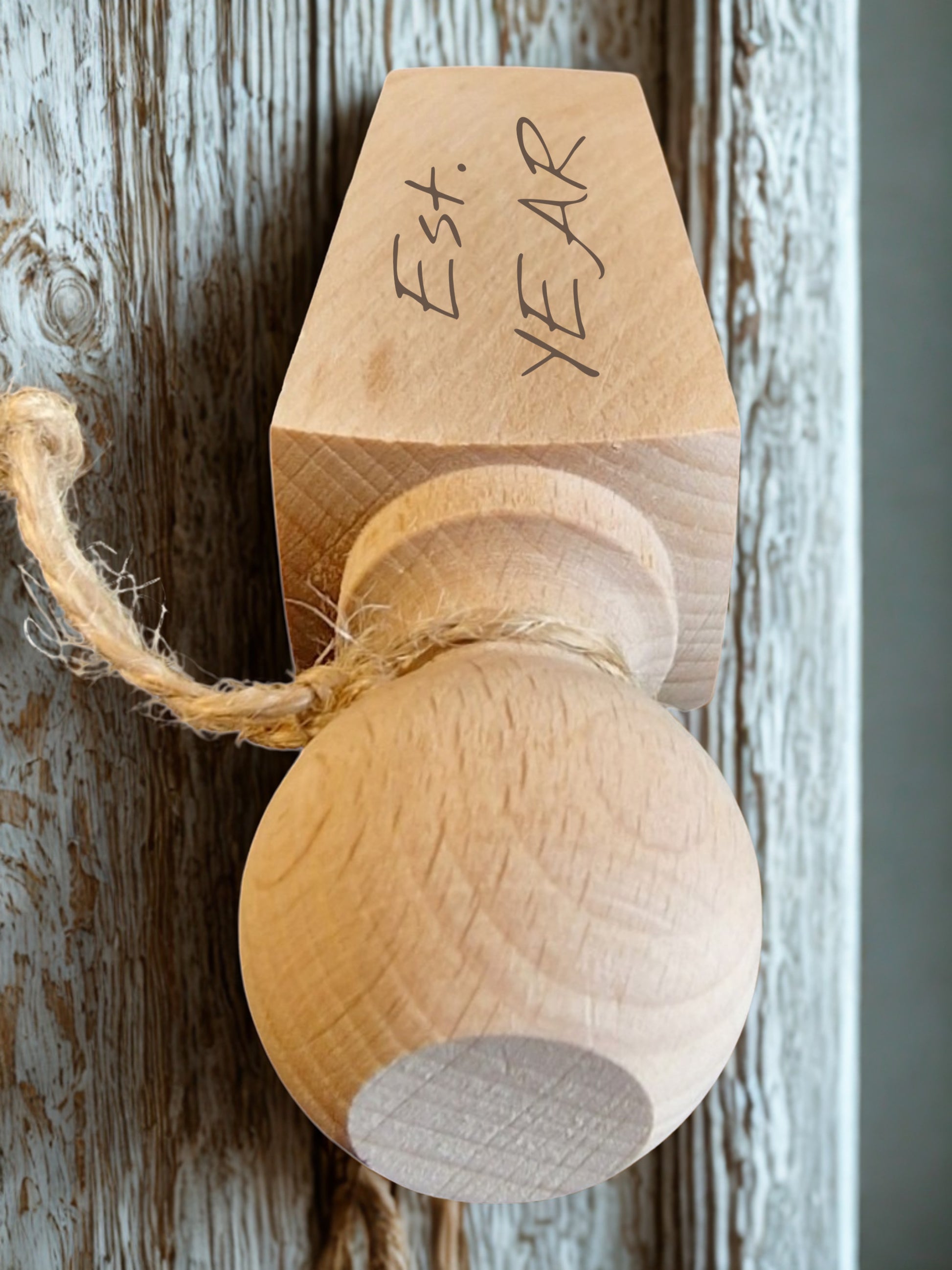 Wooden ball with a cardboard top labeled 'Est. Year' on a rustic wooden background