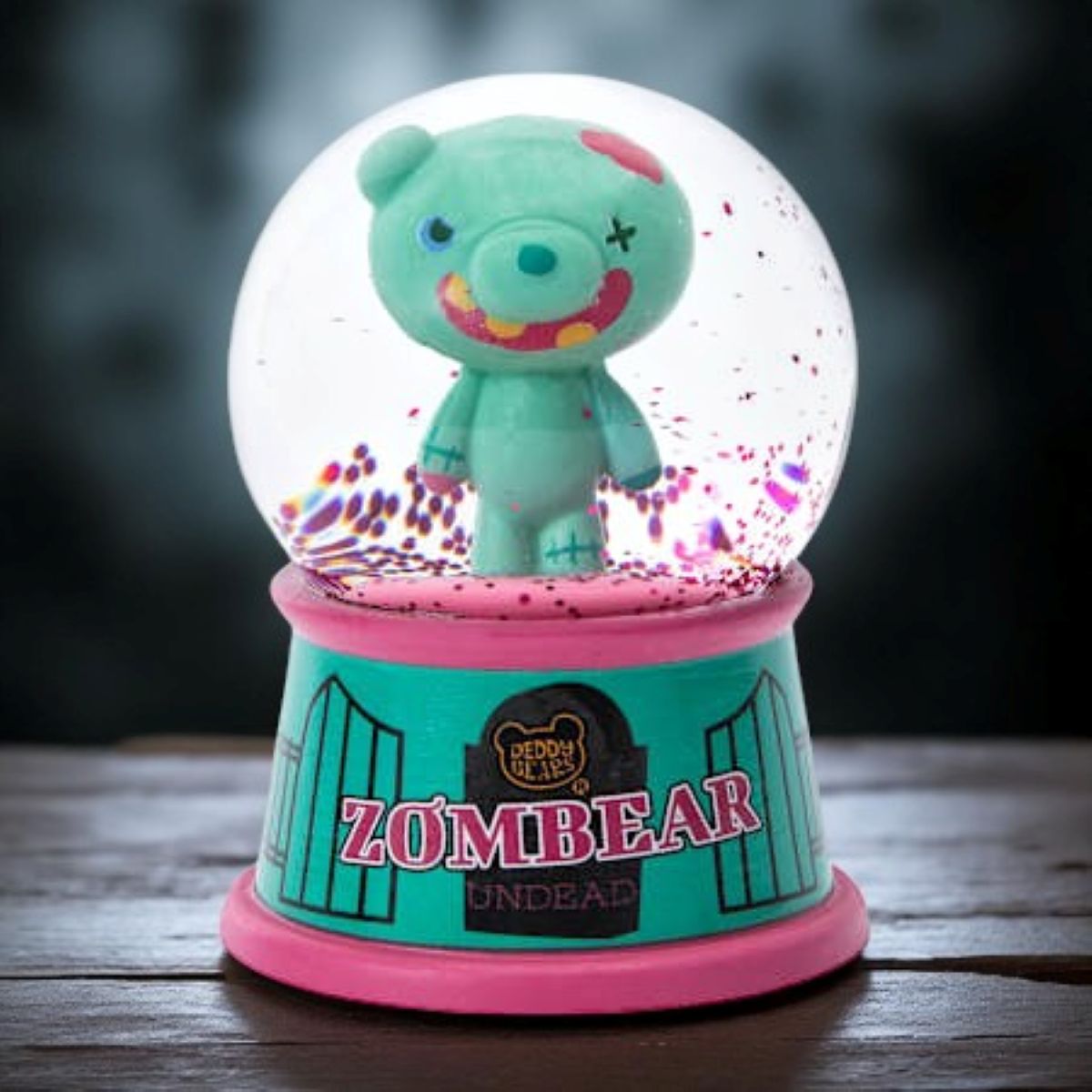 Alt text: Deddy Bears Zombiebear Mini Snow Globe with green bear figurine inside, pink and teal base, new in box.
