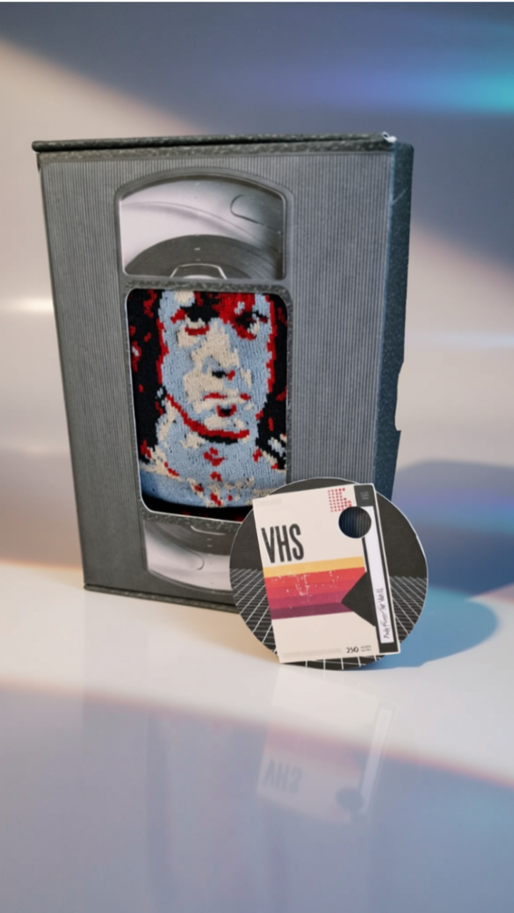 VHS tape with a cat design and VHS tape cover on a reflective surface