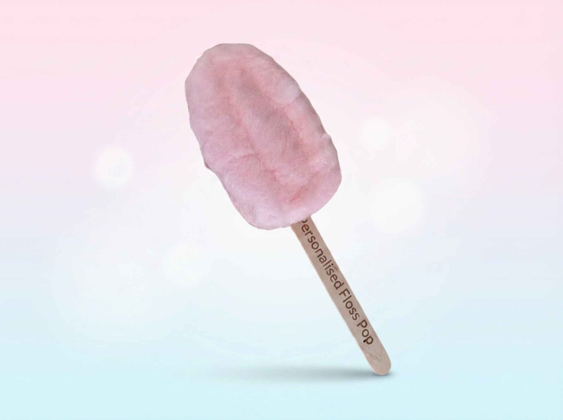 Pink cotton candy on a stick against a gradient background