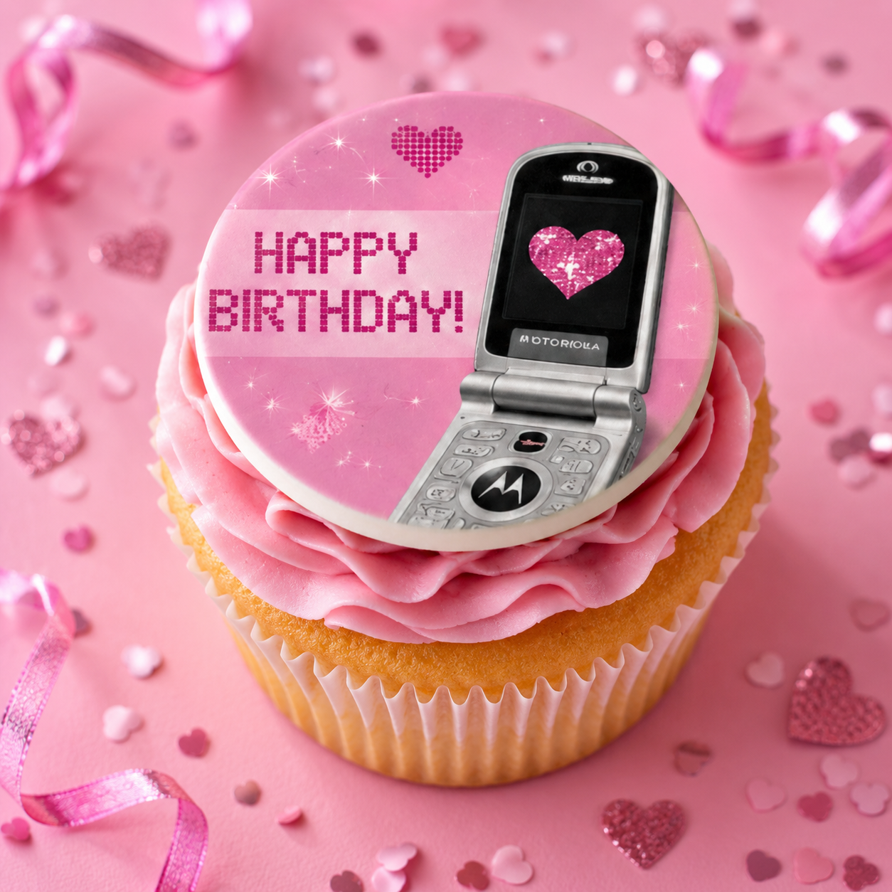 Cupcake with pink frosting and a vintage phone on top, surrounded by pink ribbons and hearts.