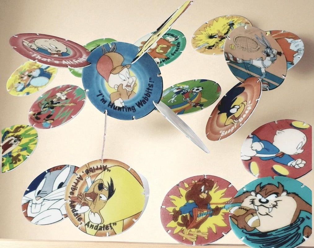 Colorful spinning toy with cartoon character designs on a beige background