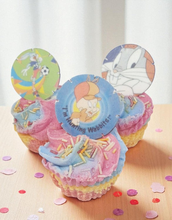 Decorative cupcakes with cartoon character toppers on a light surface.