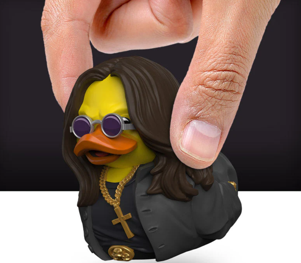 Duck figure with long hair and sunglasses held by a hand against a black background