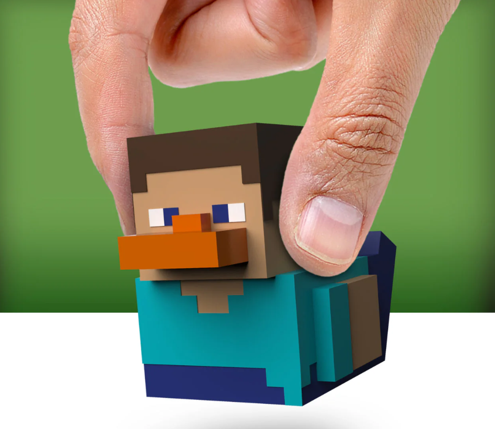 Small figurine resembling a character from a video game held between two fingers against a green background