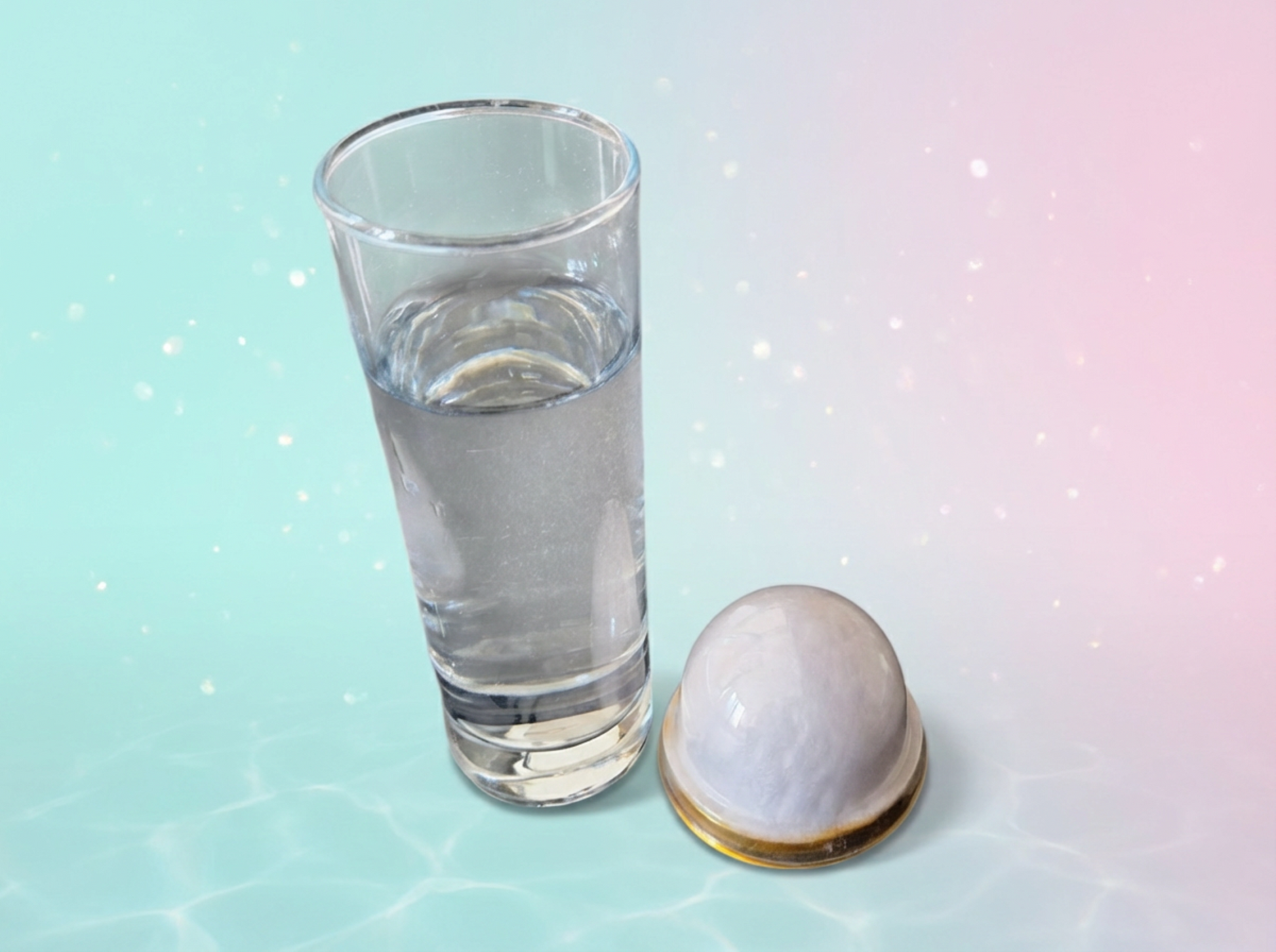 Clear glass of water next to a small white object on a light blue background