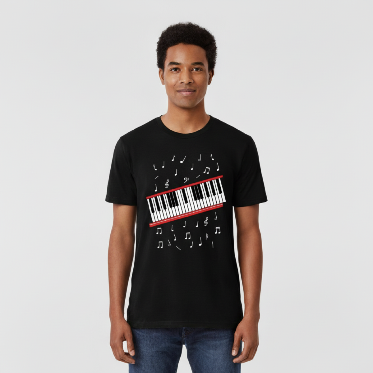 Person wearing a black t-shirt with a piano keyboard and music notes design on a plain background
