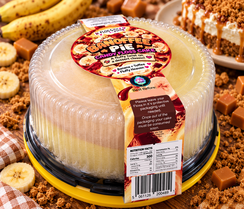 A round plastic-wrapped and labeled 'Flourless Bandoffee Pie' cake, photographed in a styled food setting with bananas, caramel pieces, crumbs, and a slice of pie in the background.
