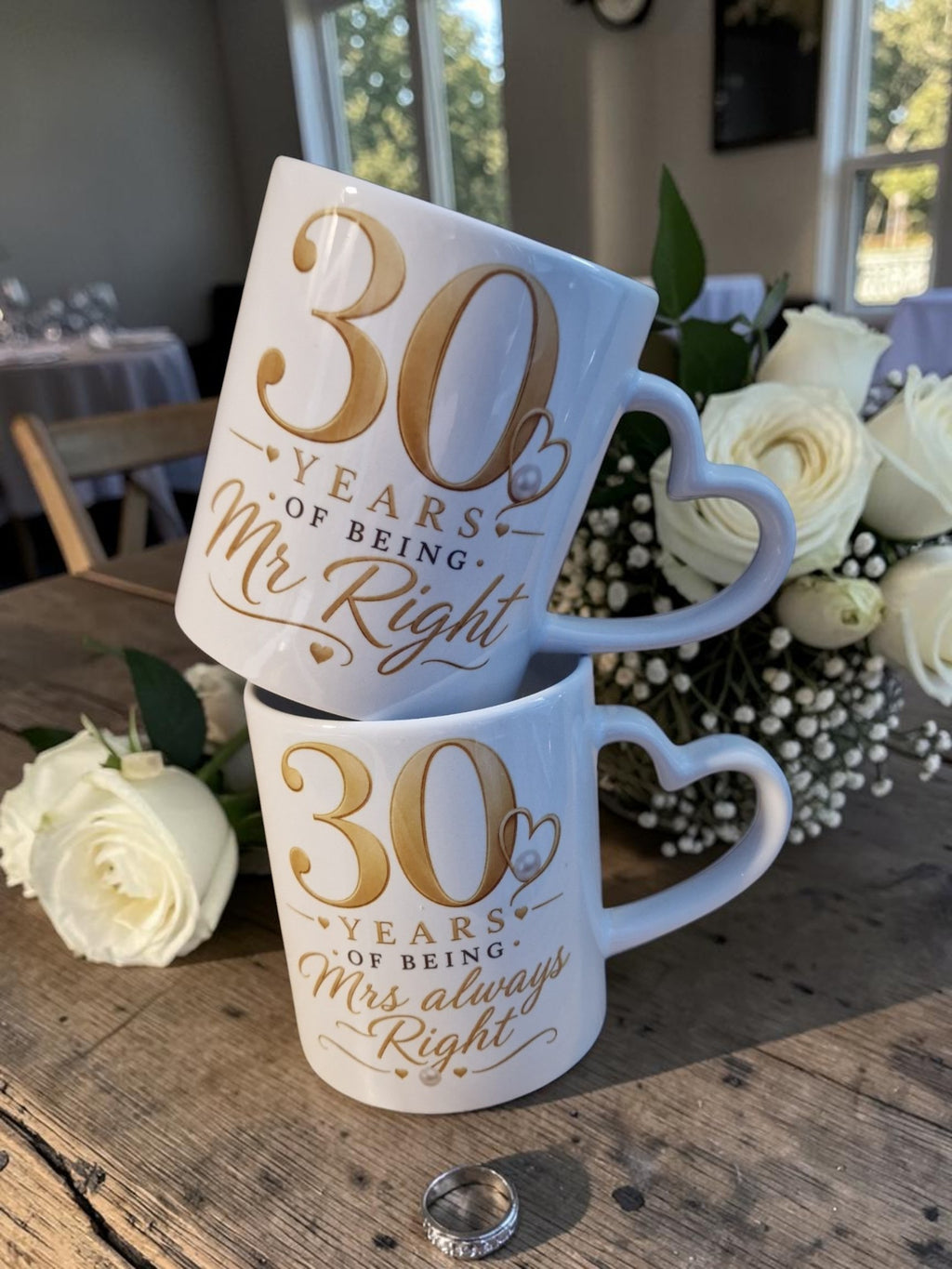 Two mugs celebrating 30 years of being 'Mr Right' and 'Mrs Always Right' on a wooden table with flowers.