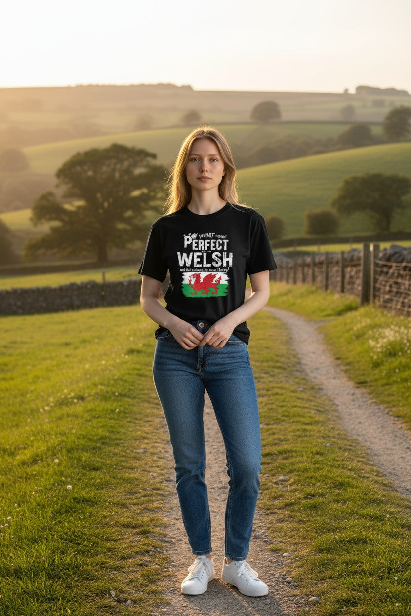 Woman wearing a black t-shirt with a Welsh flag design in a countryside setting
