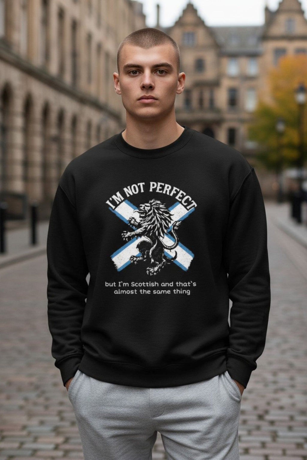 Man wearing a black sweatshirt with a Scottish design and text, standing on a street.