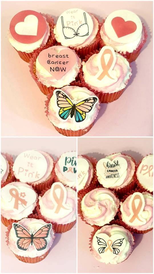 Assorted breast cancer awareness edible pre cut cake toppers featuring pink ribbons, hearts, butterflies, and supportive messages, arranged neatly on a light wood background.