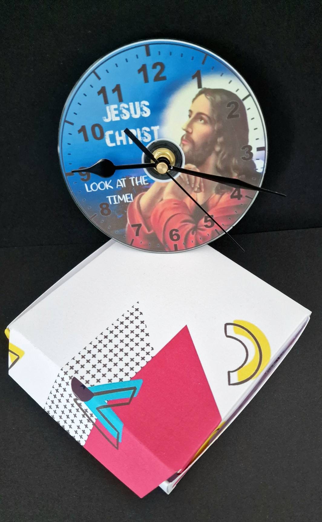 Gift boxed CD wall clock with “Jesus Christ Look at the Time” design, displayed as a unique and humorous home decor gift.