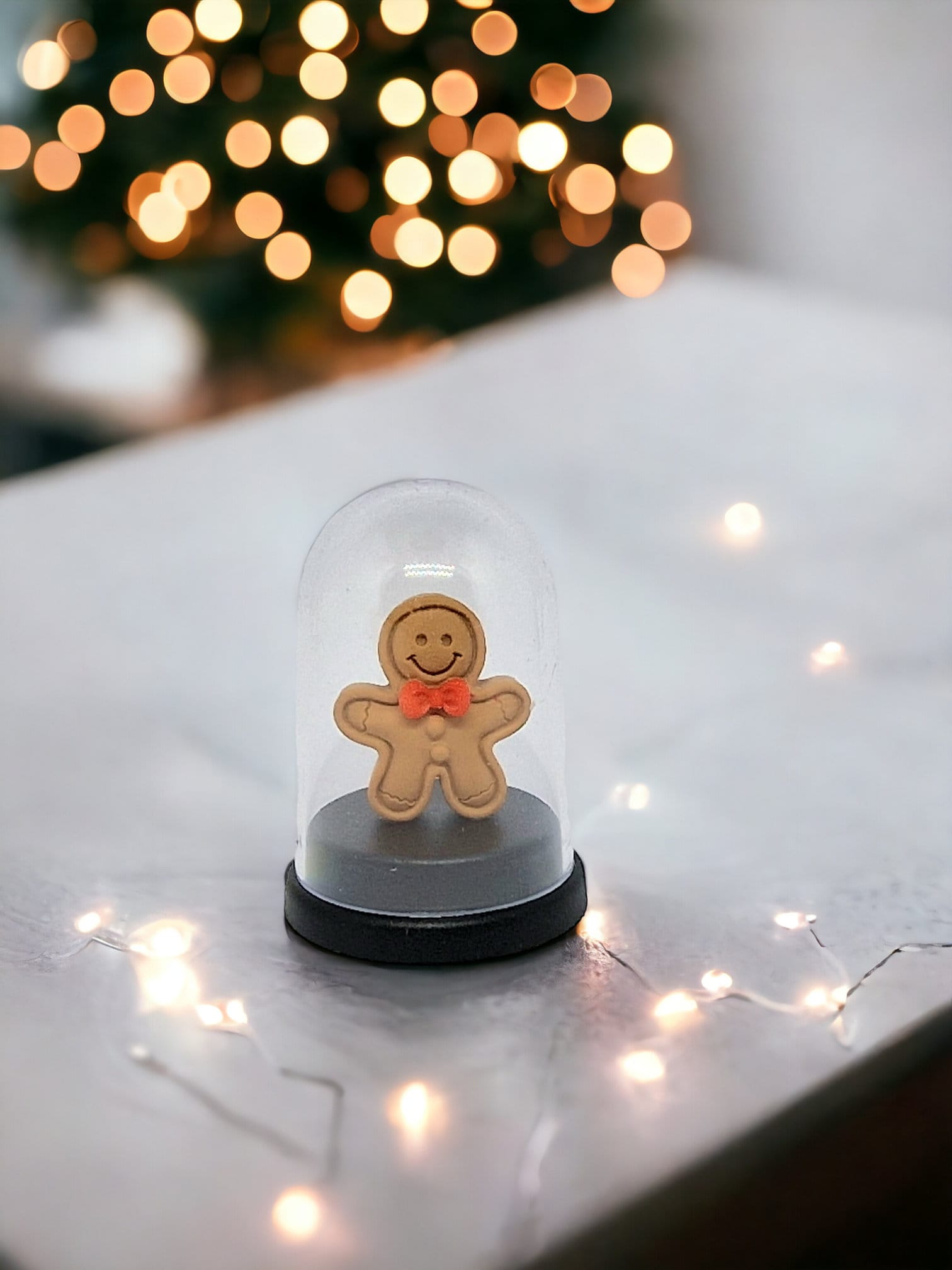 Miniature 5cm pet gingerbread man inside a small gingerbread house, displayed as a fun gift for Secret Santa or birthdays.