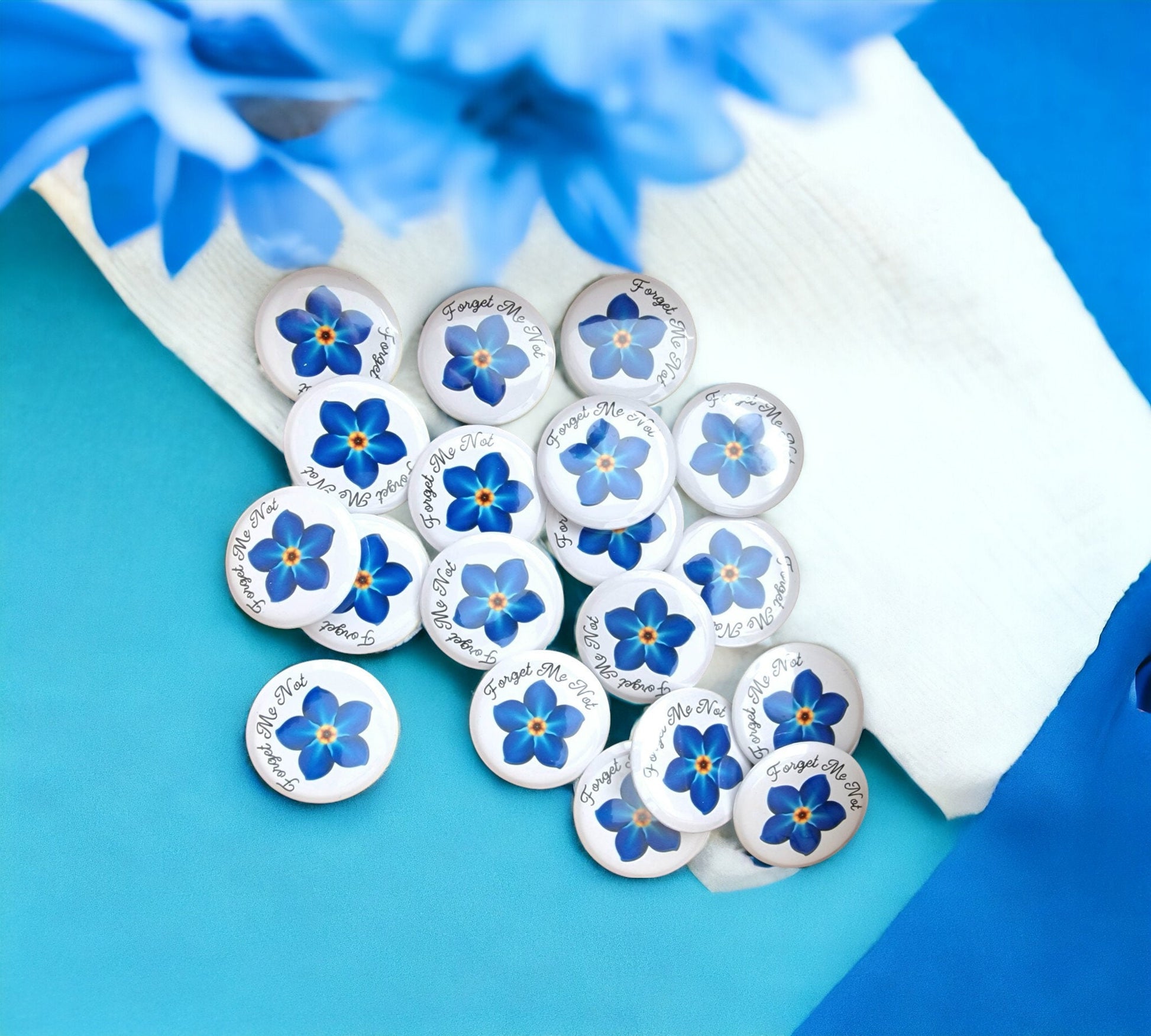 Set of 20 forget me not funeral badges on personalised “In Loving Memory” cards, displayed as keepsake mementos for funerals or dementia remembrance.