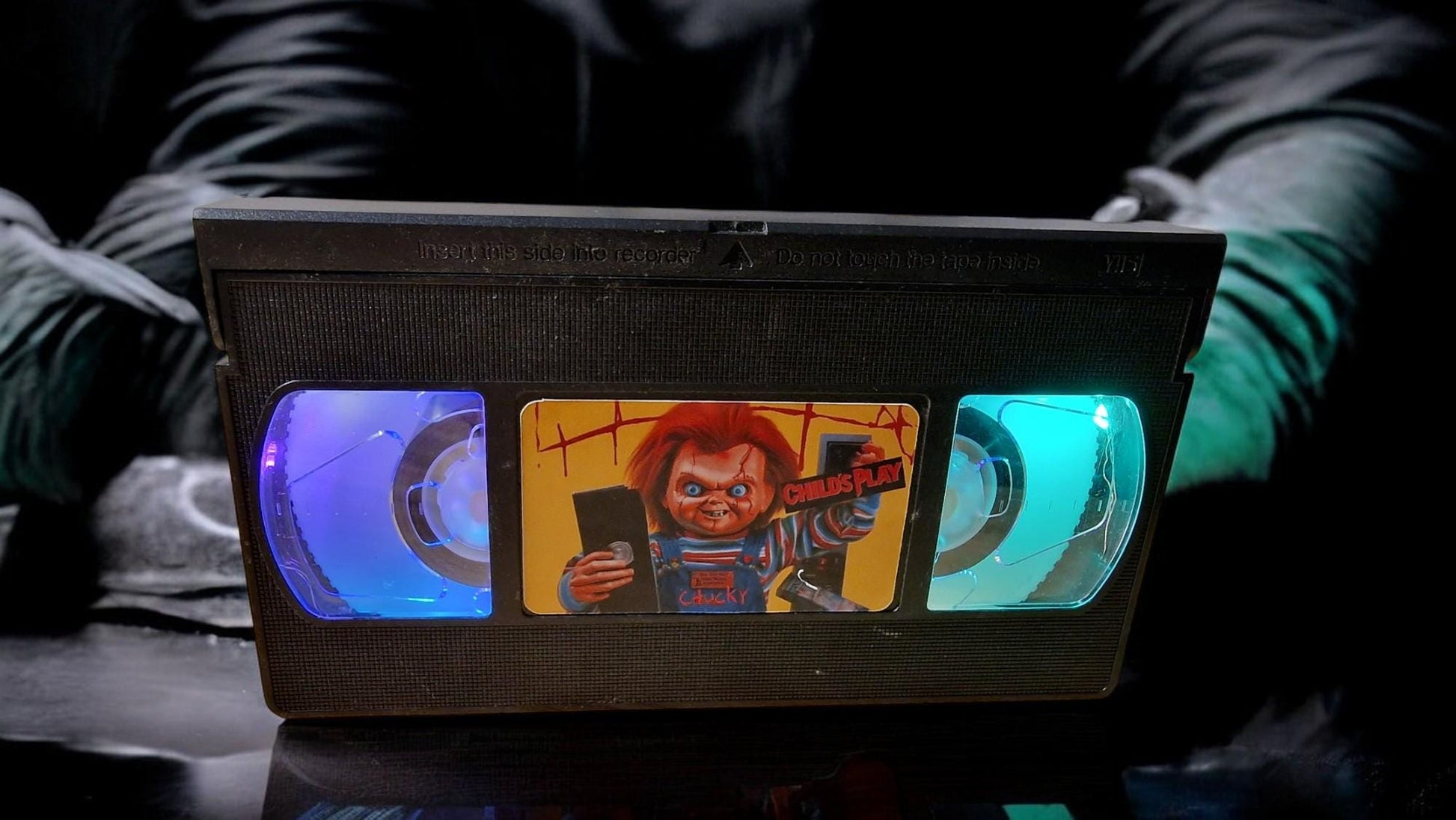 Upcycled Chucky VHS table lamp with flashing light modes, shown as a unique horror fan collectible and movie-themed decor.