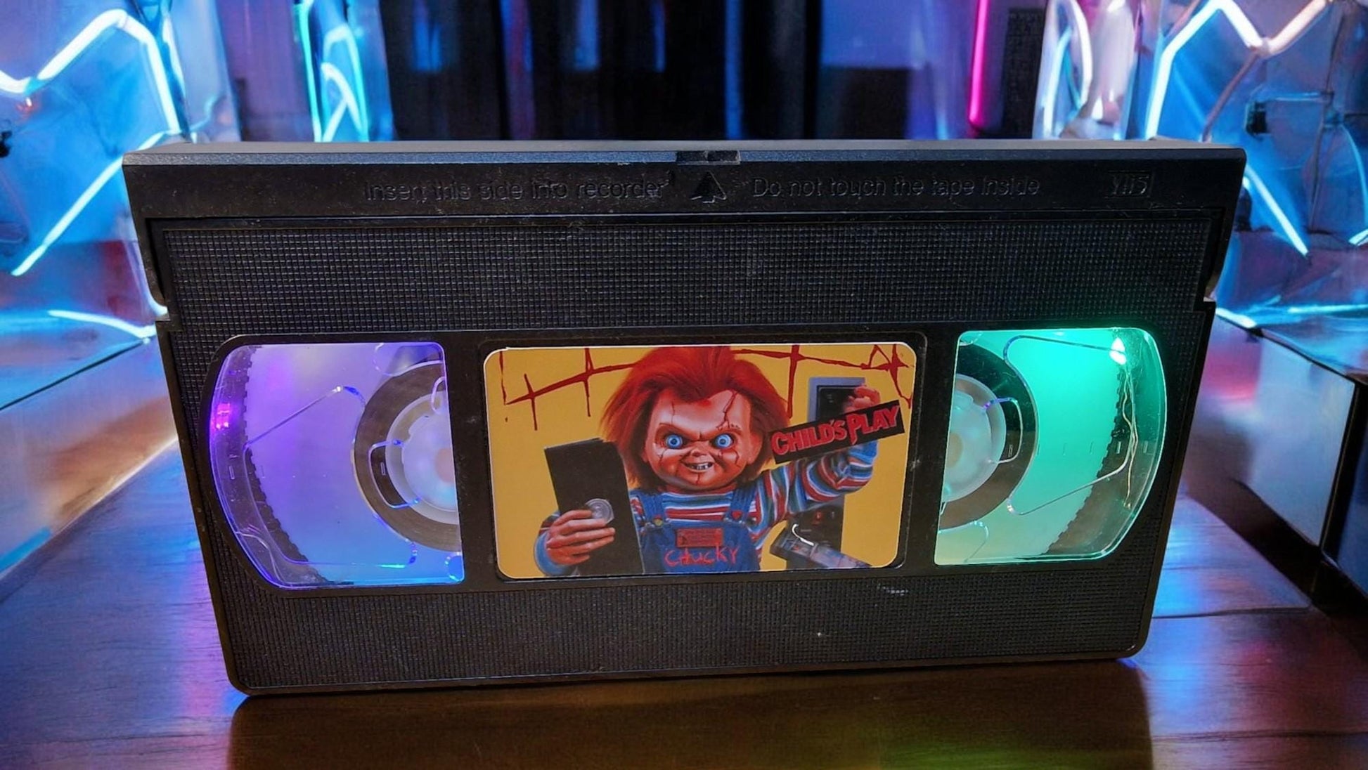 Upcycled Chucky VHS table lamp with flashing light modes, shown as a unique horror fan collectible and movie-themed decor.