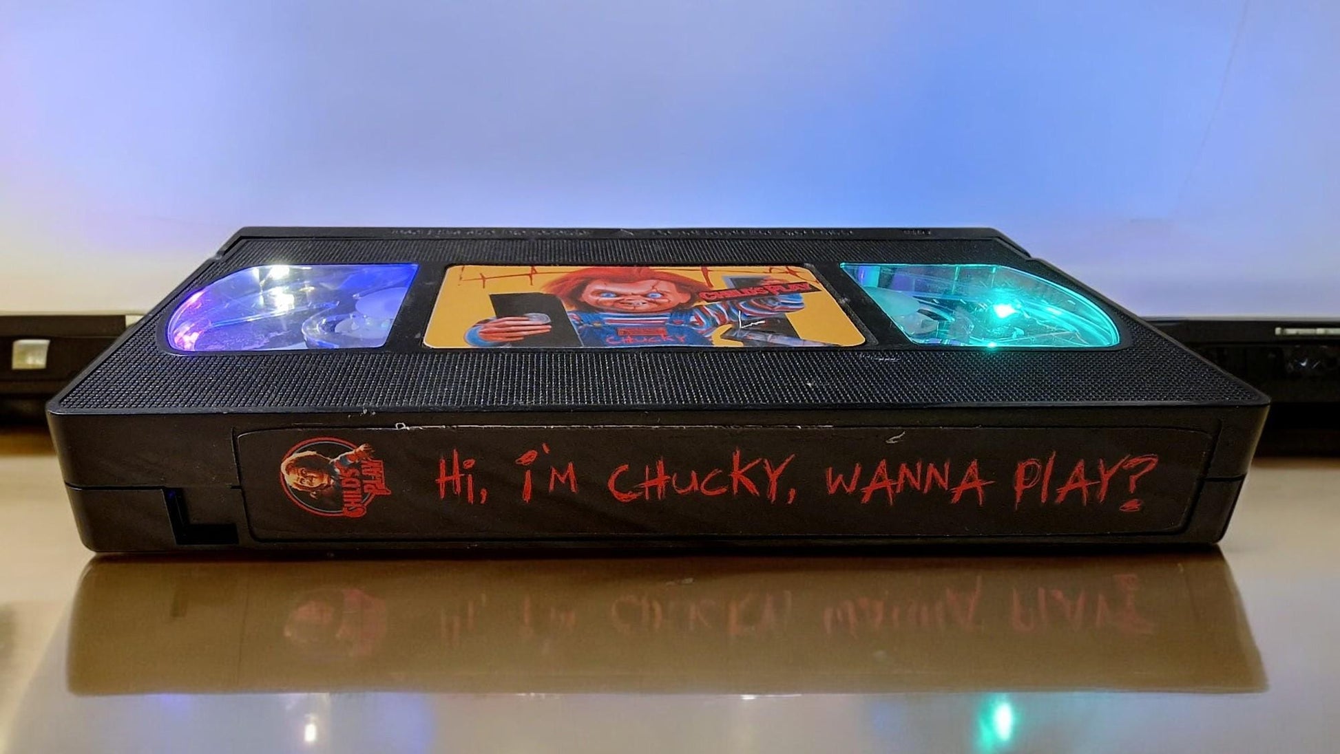 Upcycled Chucky VHS table lamp with flashing light modes, shown as a unique horror fan collectible and movie-themed decor.