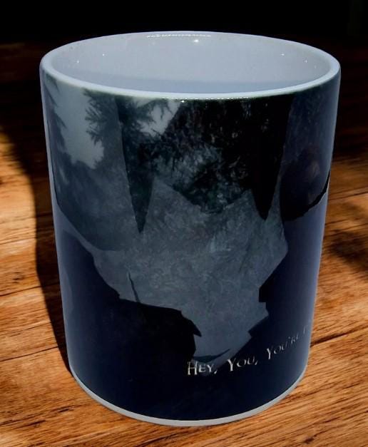 Black color change mug with “Hey you’re finally awake” Ralof design revealed by heat, shown as a fun gamer and coffee lover gift.