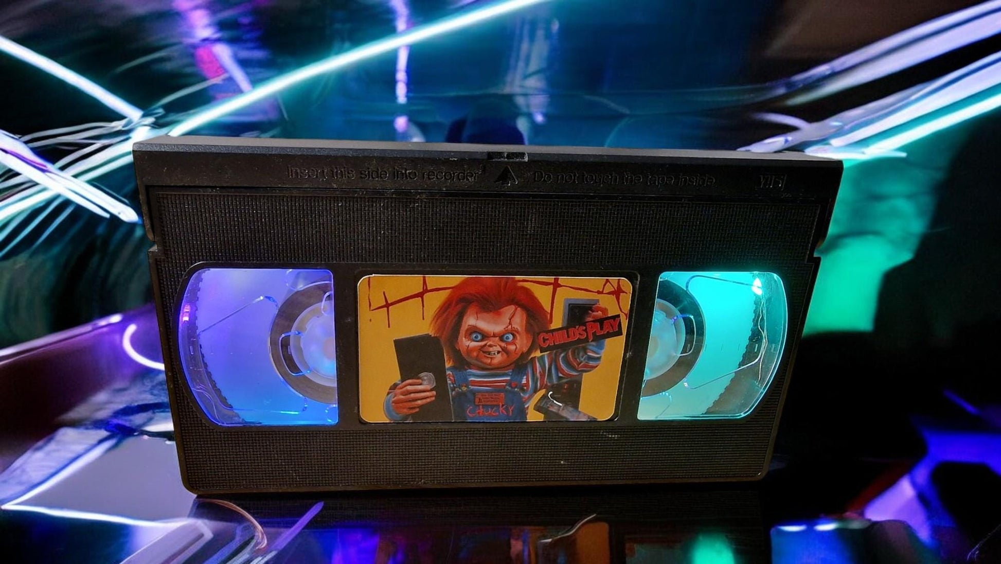Upcycled Chucky VHS table lamp with flashing light modes, shown as a unique horror fan collectible and movie-themed decor.