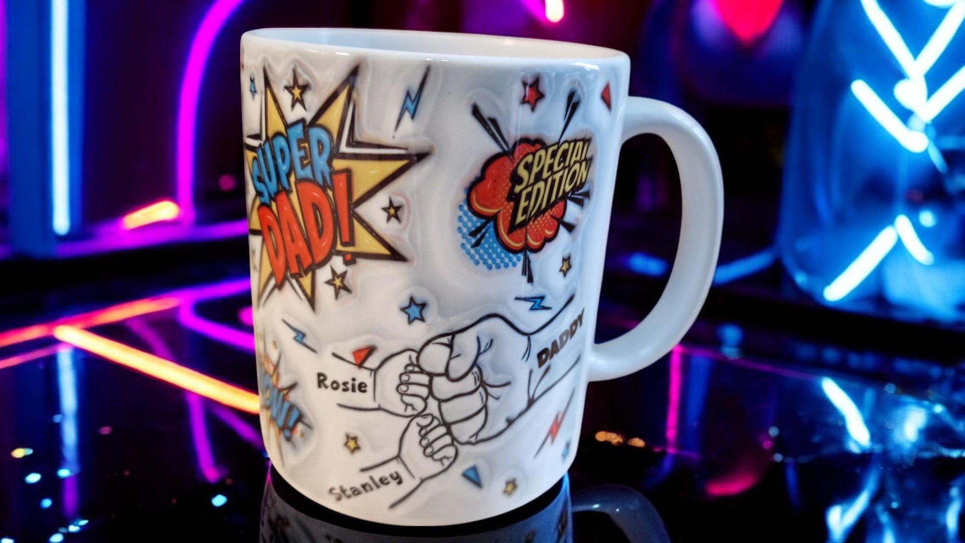 White ceramic mug with comic book “Super Dad!” and “Special Edition” graphics, plus a fist-bump illustration personalised with kids’ names