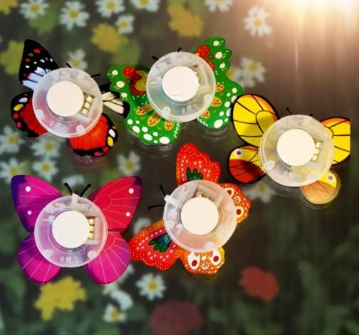 Set of five colourful butterfly LED night lights flashing on a wall, shown as fun party and room decor.
