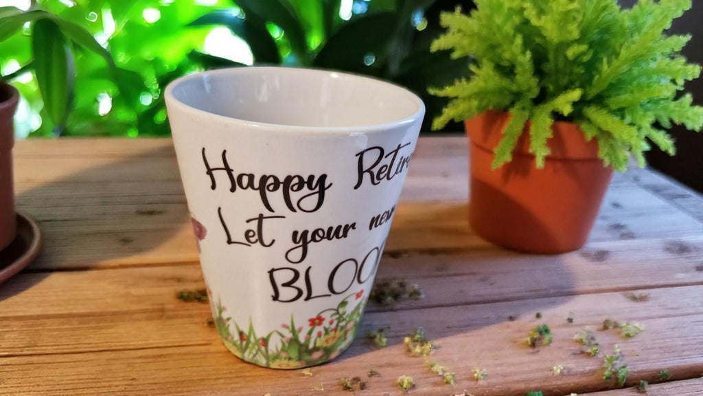 Personalised ceramic plant pot with “Happy Retirement – Let Your New Life Bloom” message, ideal as a leaving gift.