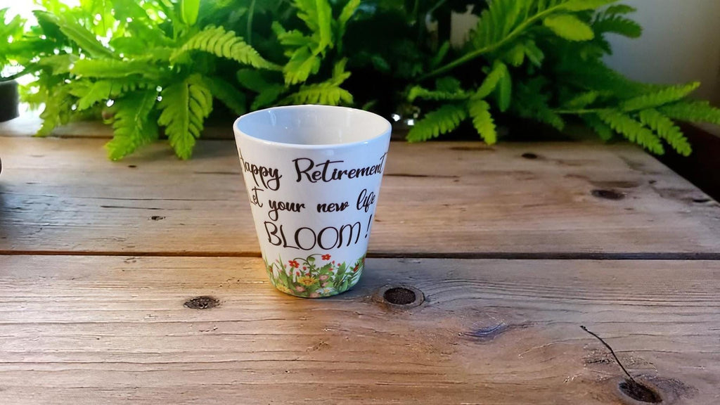 Personalised ceramic plant pot with “Happy Retirement – Let Your New Life Bloom” message, ideal as a leaving gift.