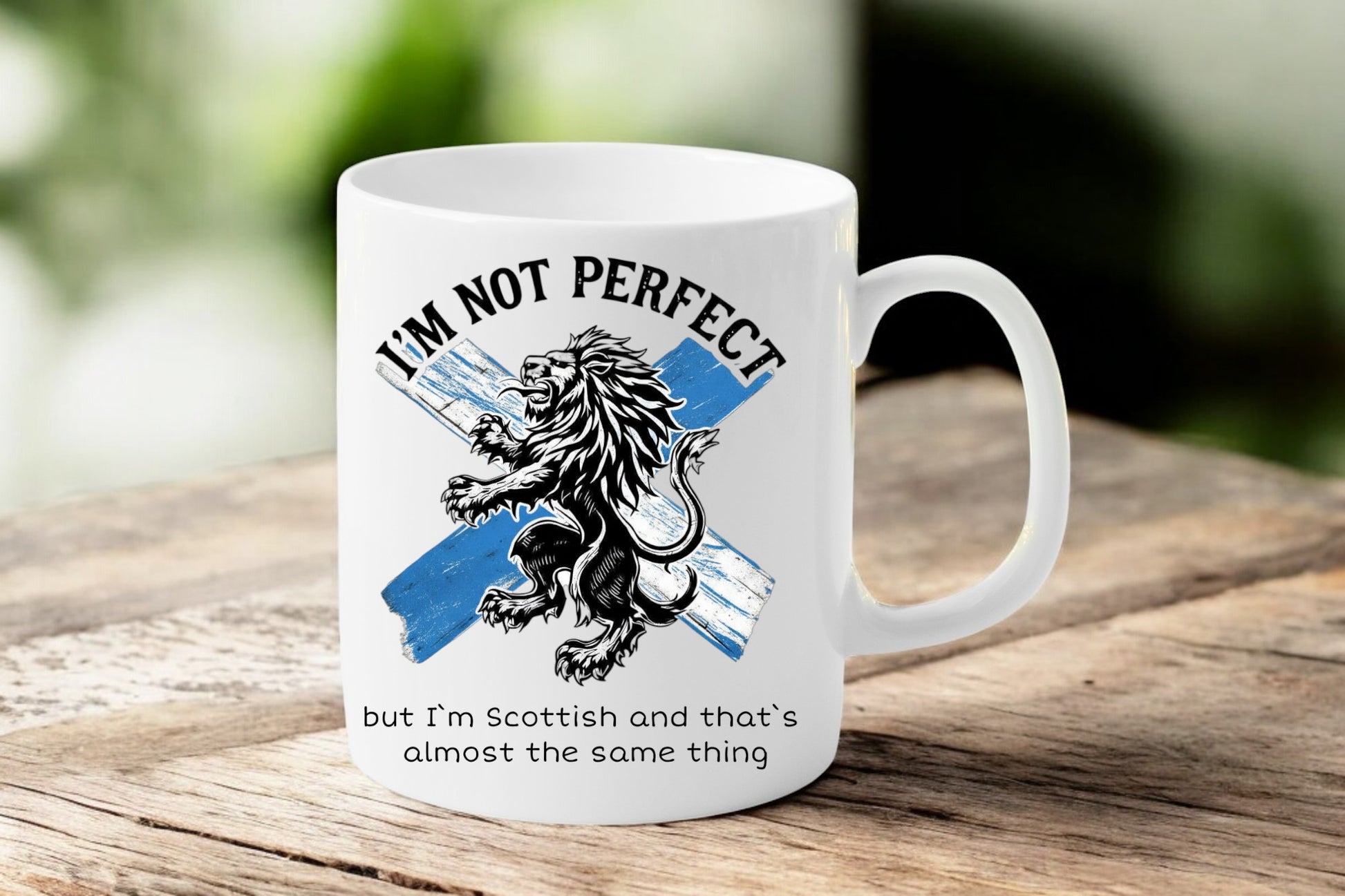 White mug with Scottish lion design and text on a wooden surface