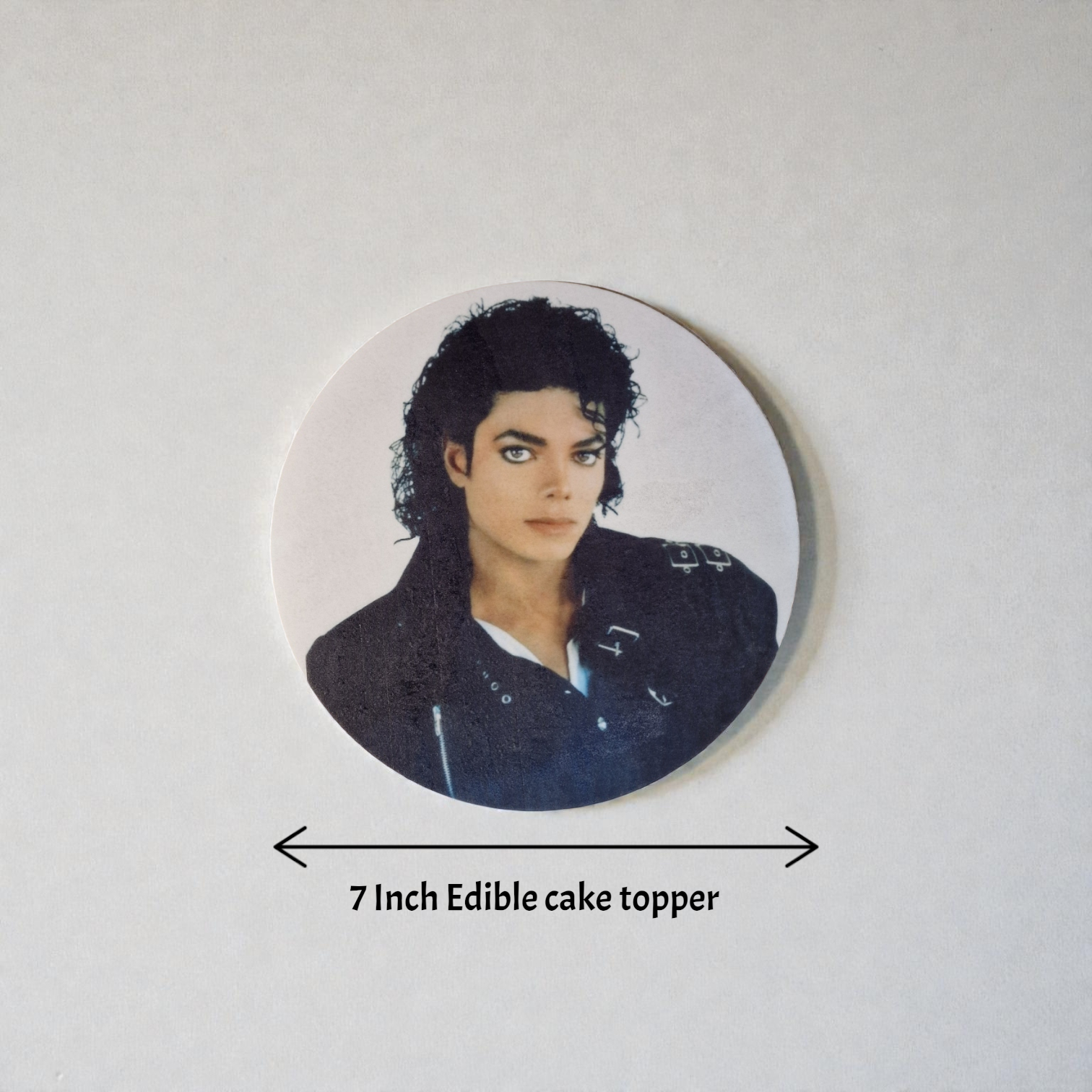 Circular edible cake topper with a portrait of a famous person on a white background
