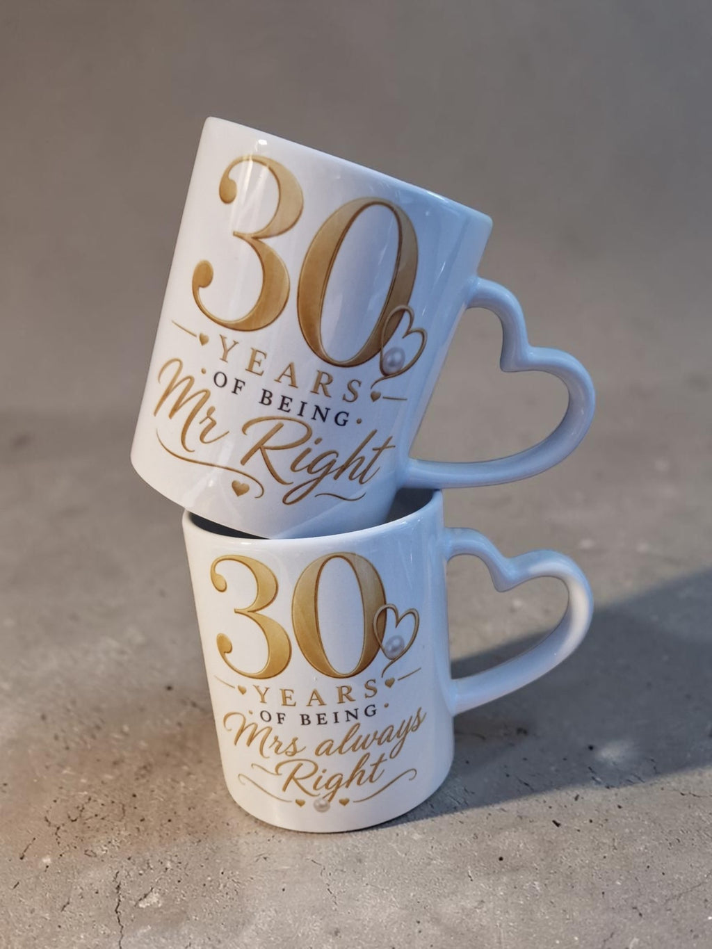 Two mugs with '30 years of being Mr Right' and '30 years of being Mrs always Right' text on a concrete surface.